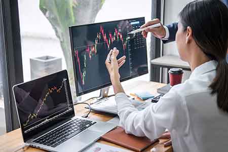 Person sitting at computer backtesting their trading plan